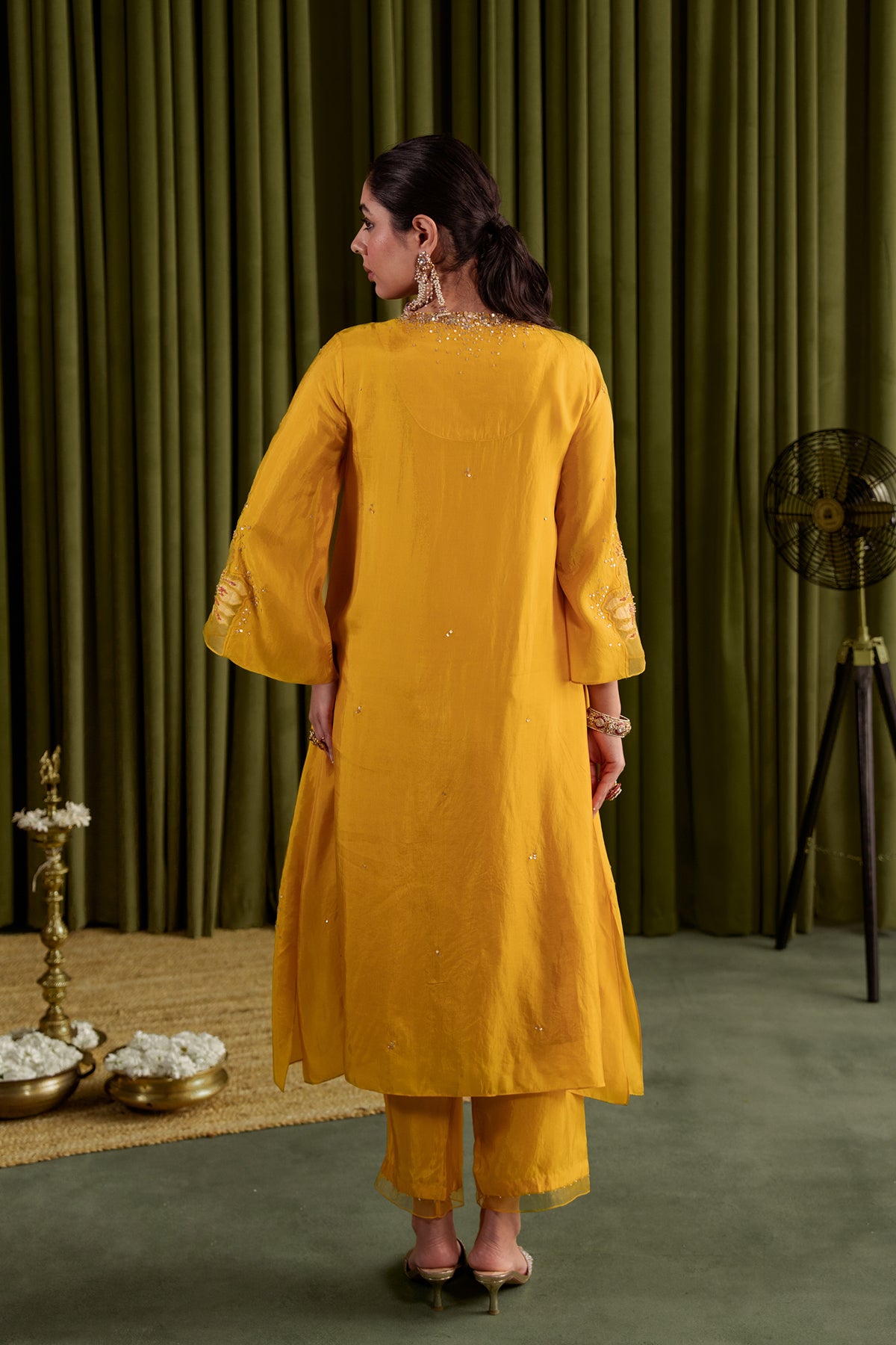 Golden yellow kurta set in viscose silk base with embroidered magnolia flower pattern.