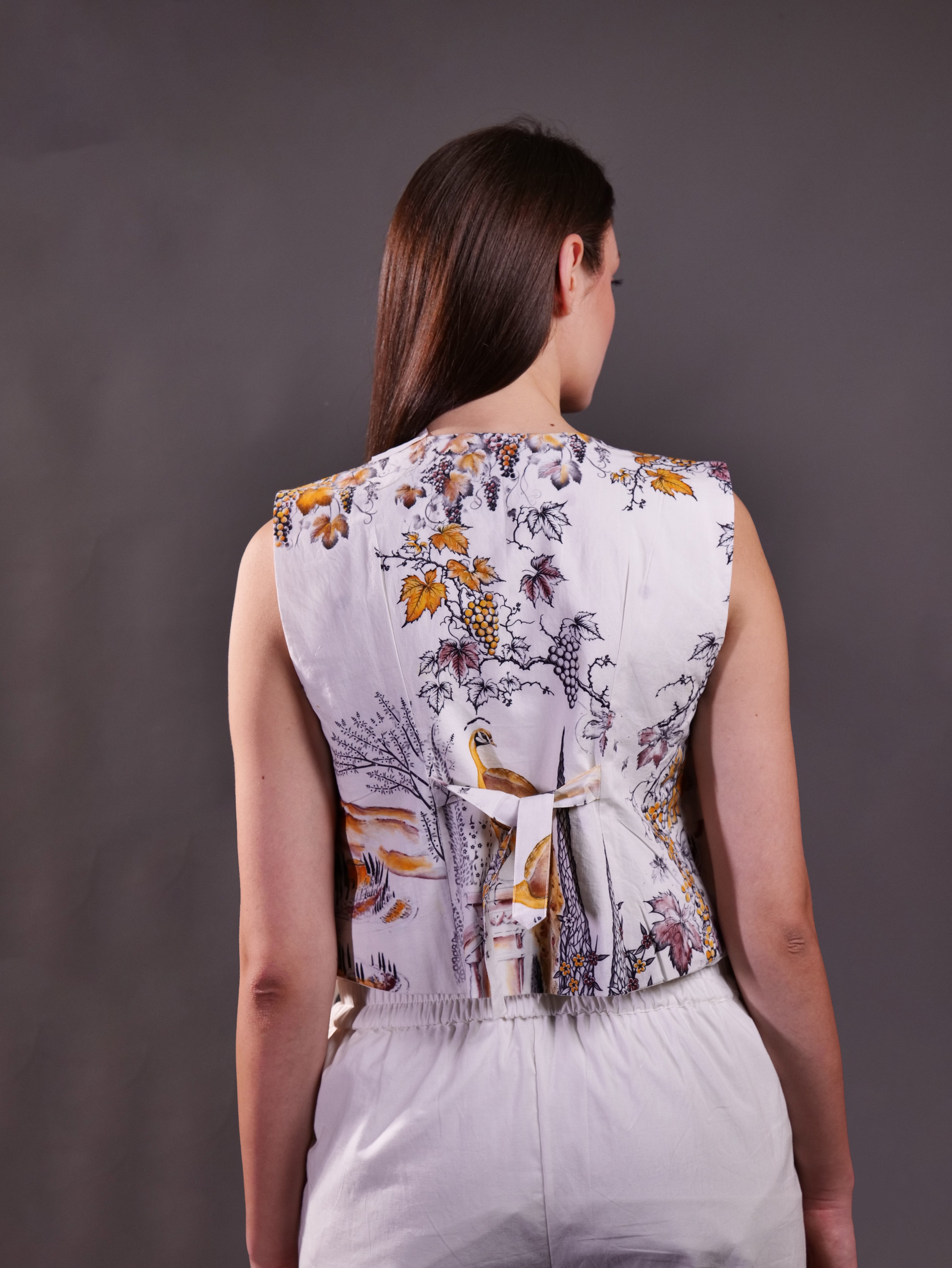 Printed Waistcoat with Embroidered Buttons layered over Solid Ivory Sleeveless Top and Trousers