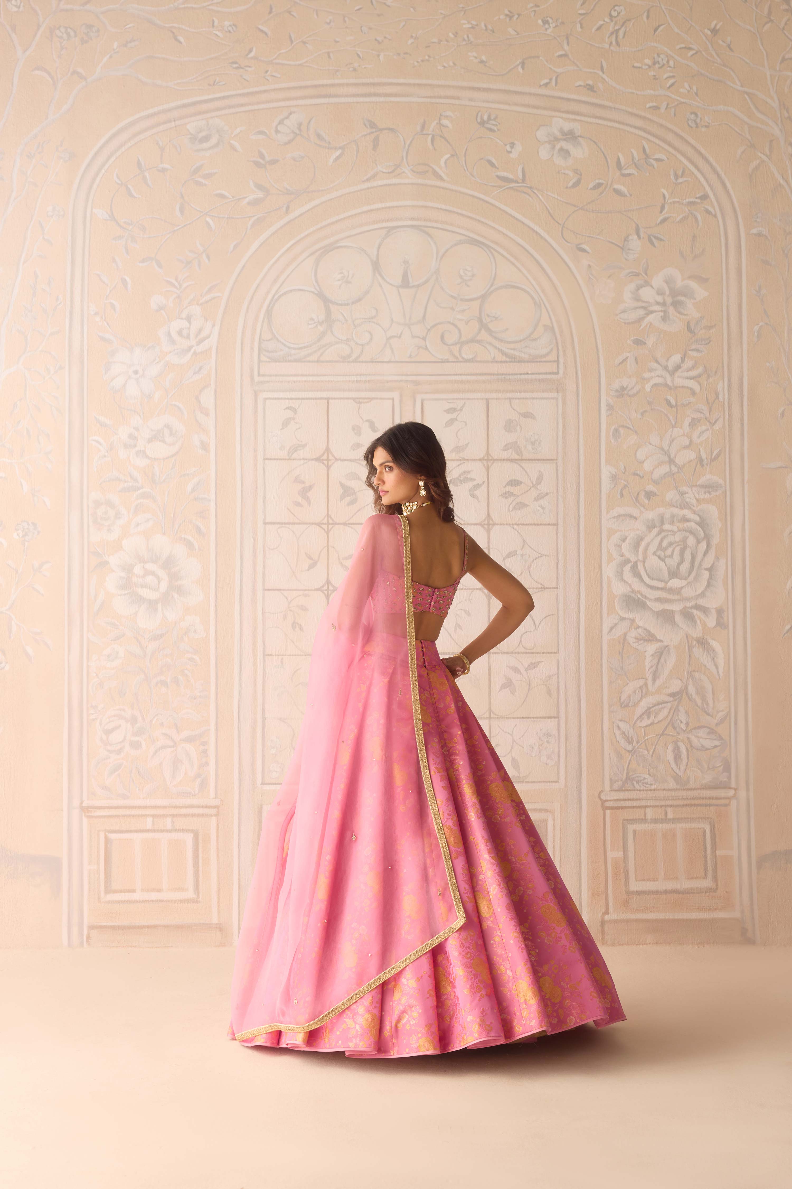 Coral pink brocade pleated lehenga with zardozi embroidered sleeveless blouse paired with organza dupatta