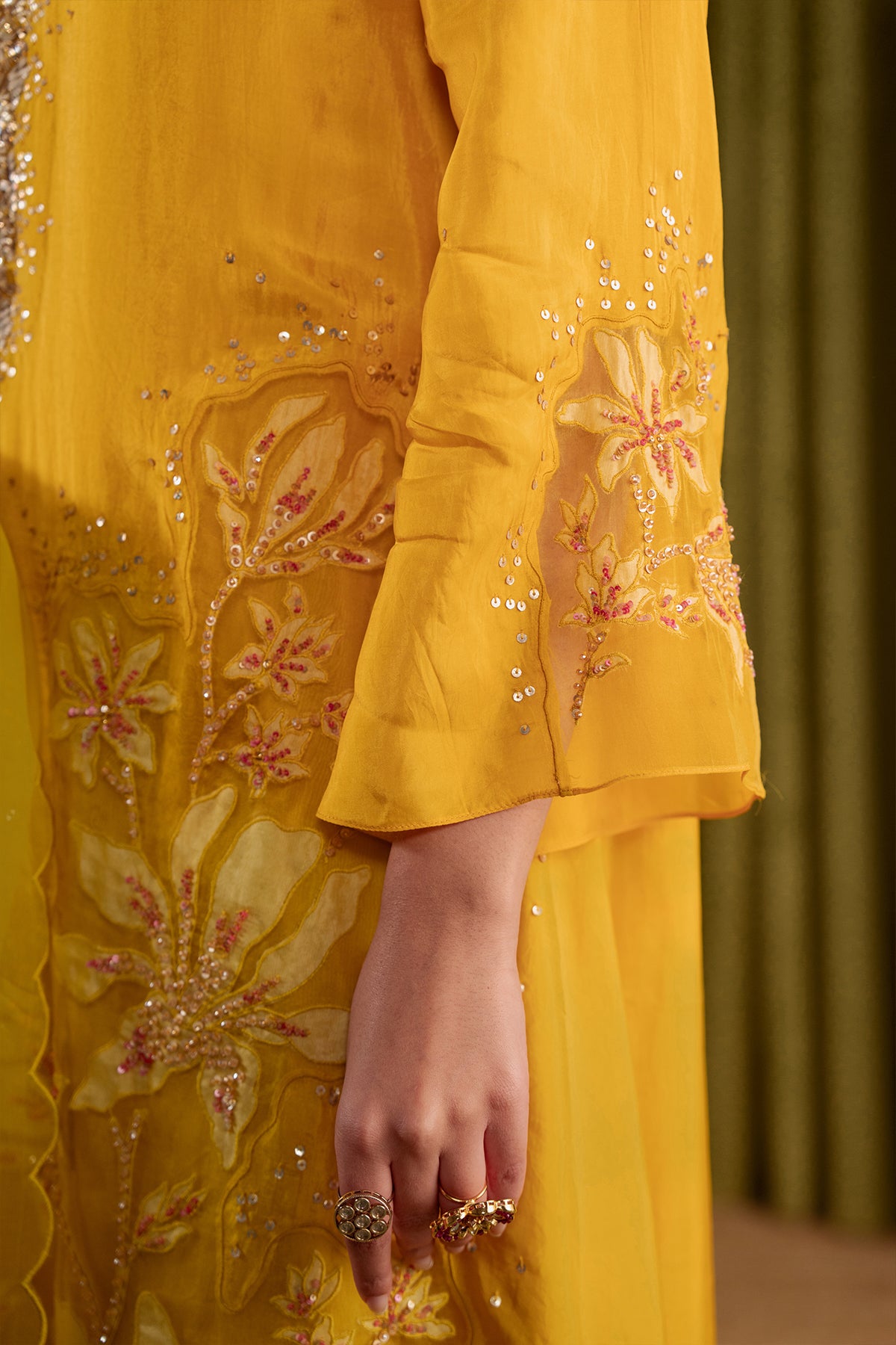 Golden yellow kurta set in viscose silk base with embroidered magnolia flower pattern.