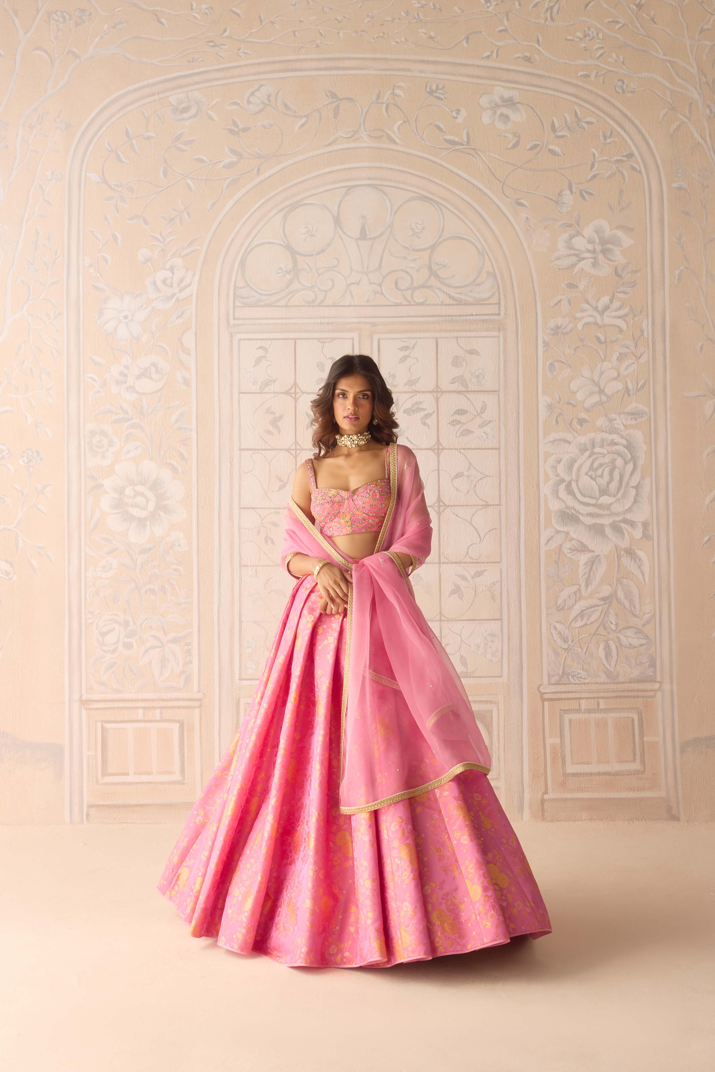 Coral pink brocade pleated lehenga with zardozi embroidered sleeveless blouse paired with organza dupatta
