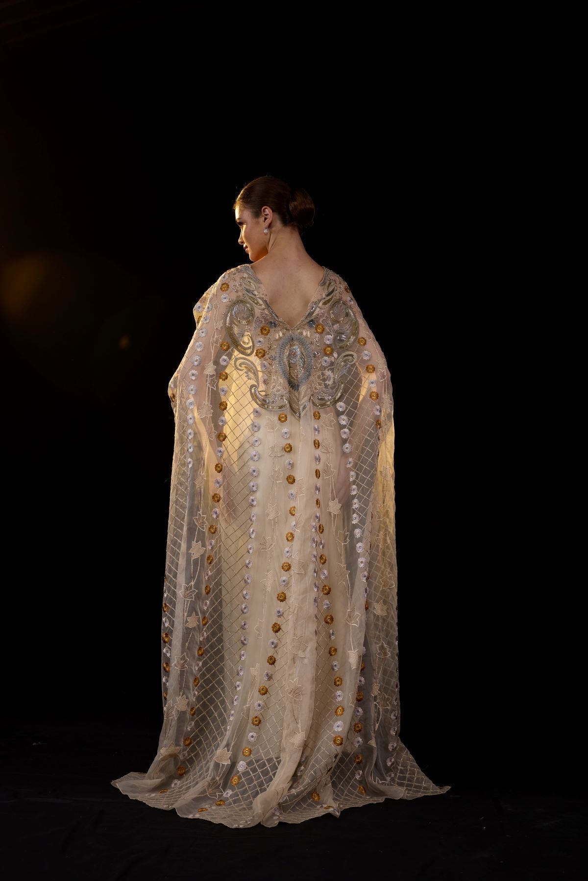 https://cdn.shopify.com/s/files/1/0088/3441/6706/files/a-sheer-neck-floor-length-embroidered-gown-cape-drapes-from-the-shoulders-3592971.jpg?v=1752388530