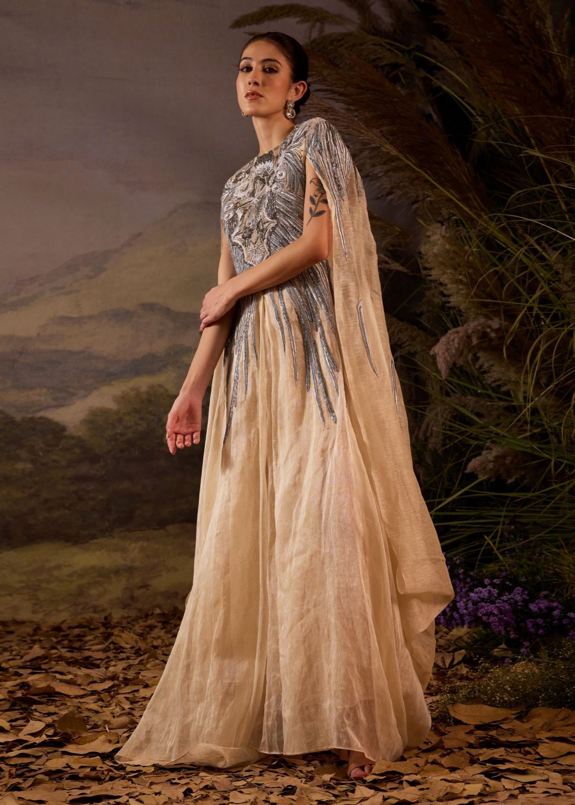 https://cdn.shopify.com/s/files/1/0088/3441/6706/files/champagne-draped-cape-gown-with-ornate-silver-embroidery-1662357.jpg?v=1753781125