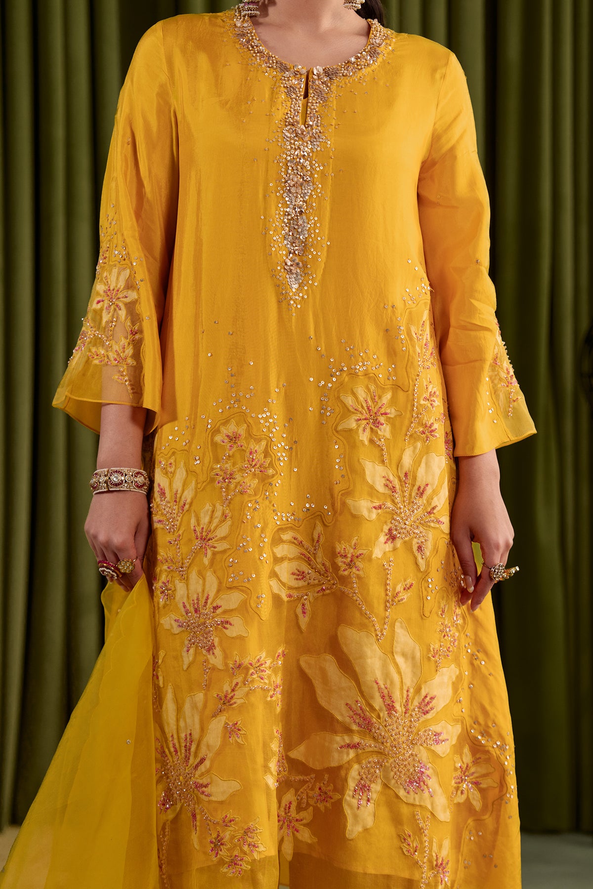 Golden yellow kurta set in viscose silk base with embroidered magnolia flower pattern.